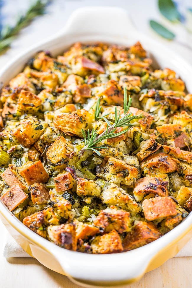 Crispy-edged herb stuffing baked in a pan with golden top and fresh herbs